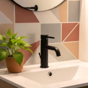 Close-up of a bathroom vanity with a self-adhesive vinyl backsplash. The backsplash features a modern geometric pattern, highlighting a quick and stylish DIY upgrade.